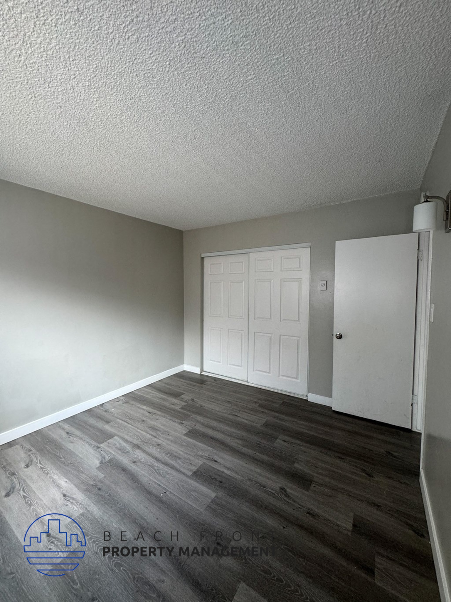 an empty living room with wood floors and a white door